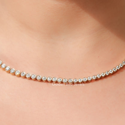 Gold-tone tennis necklace with small round clear stones in a linked row