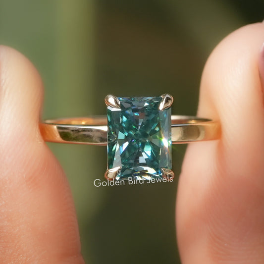 Blue radiant-cut solitaire moissanite ring with four-prong setting, slim metal band