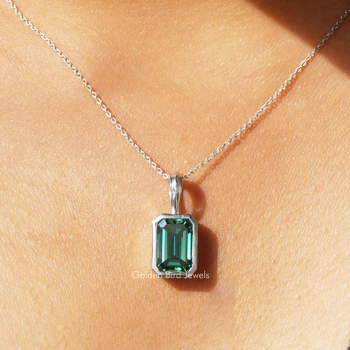 Green emerald-cut solitaire moissanite pendant on silver chain with bail
