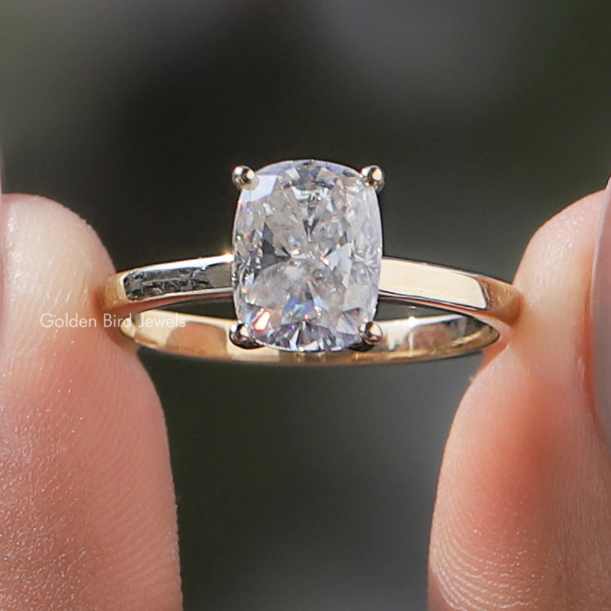Gold-tone ring with elongated cushion-cut clear moissanite, prong-set center stone