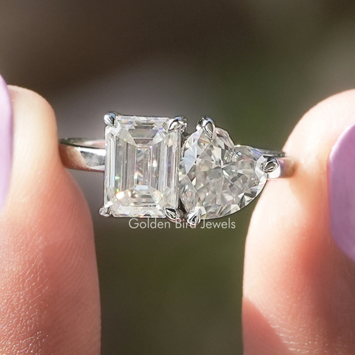 Toi et moi moissanite ring with emerald-cut and heart stones in prongs on silver band