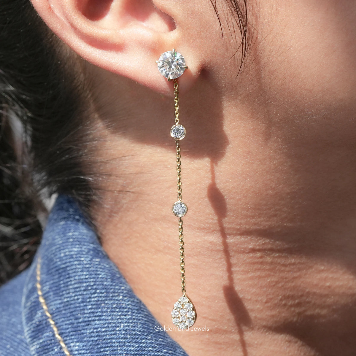 Round-cut moissanite dangle earrings with four round stones on a gold-tone chain