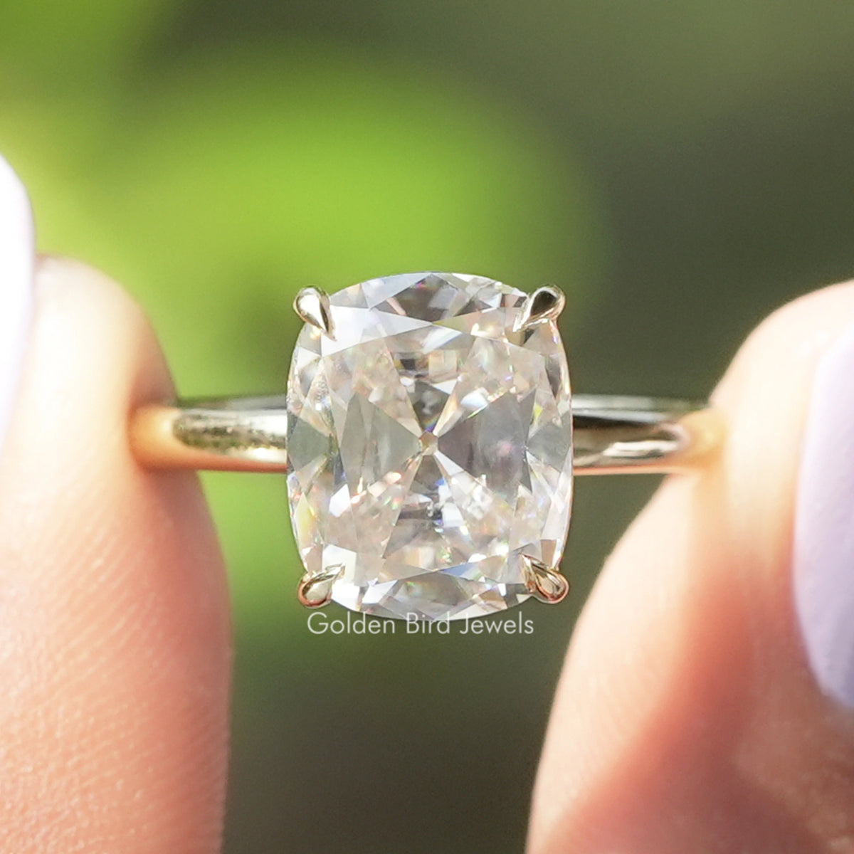 Cushion-cut solitaire moissanite ring with four-prong setting and metal band