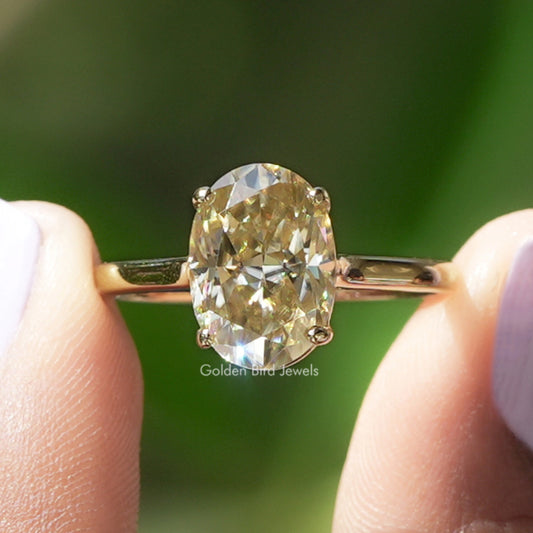 Oval-cut solitaire moissanite engagement ring with yellow gold band and oval gemstone