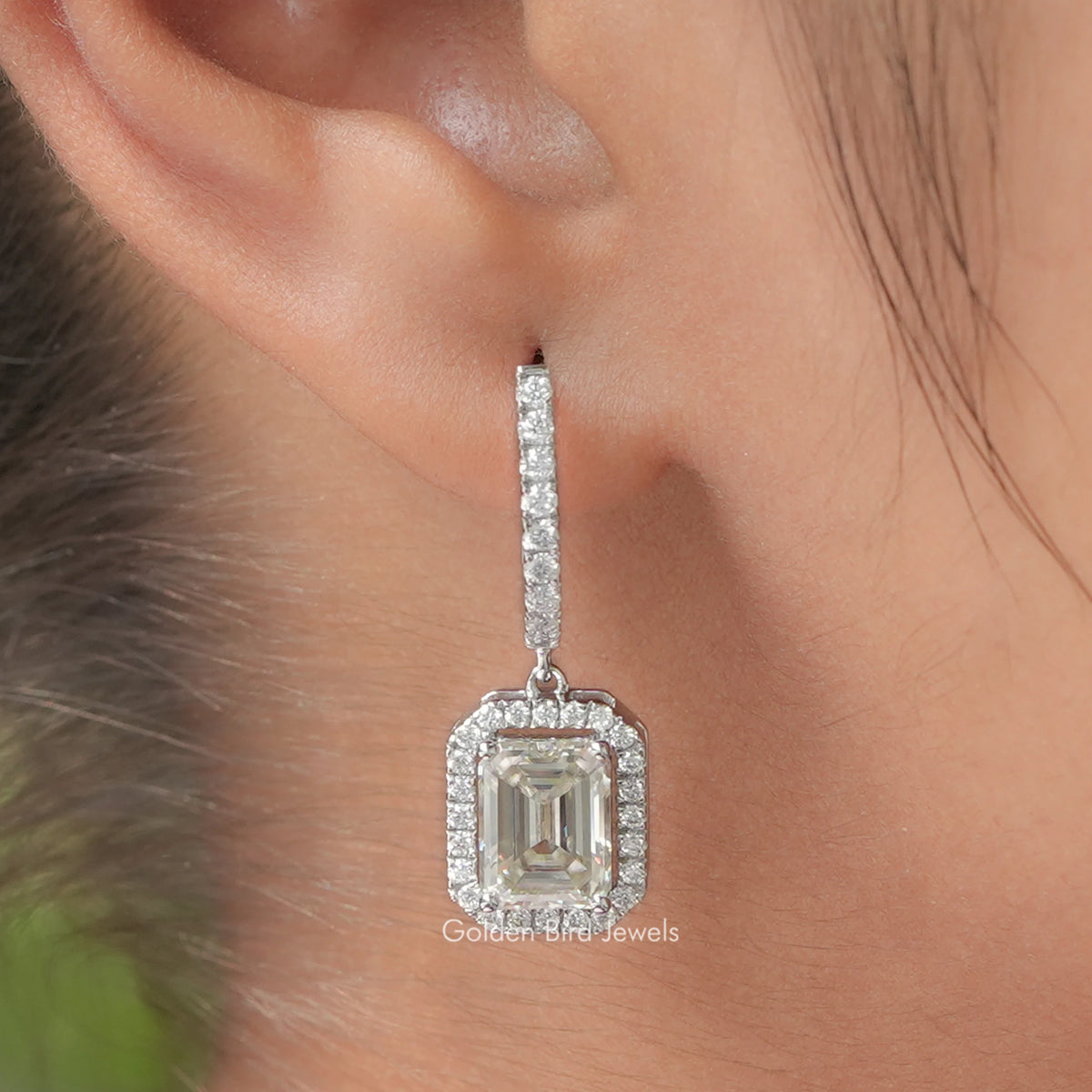 Silver emerald-cut halo drop earring close-up of square center stone