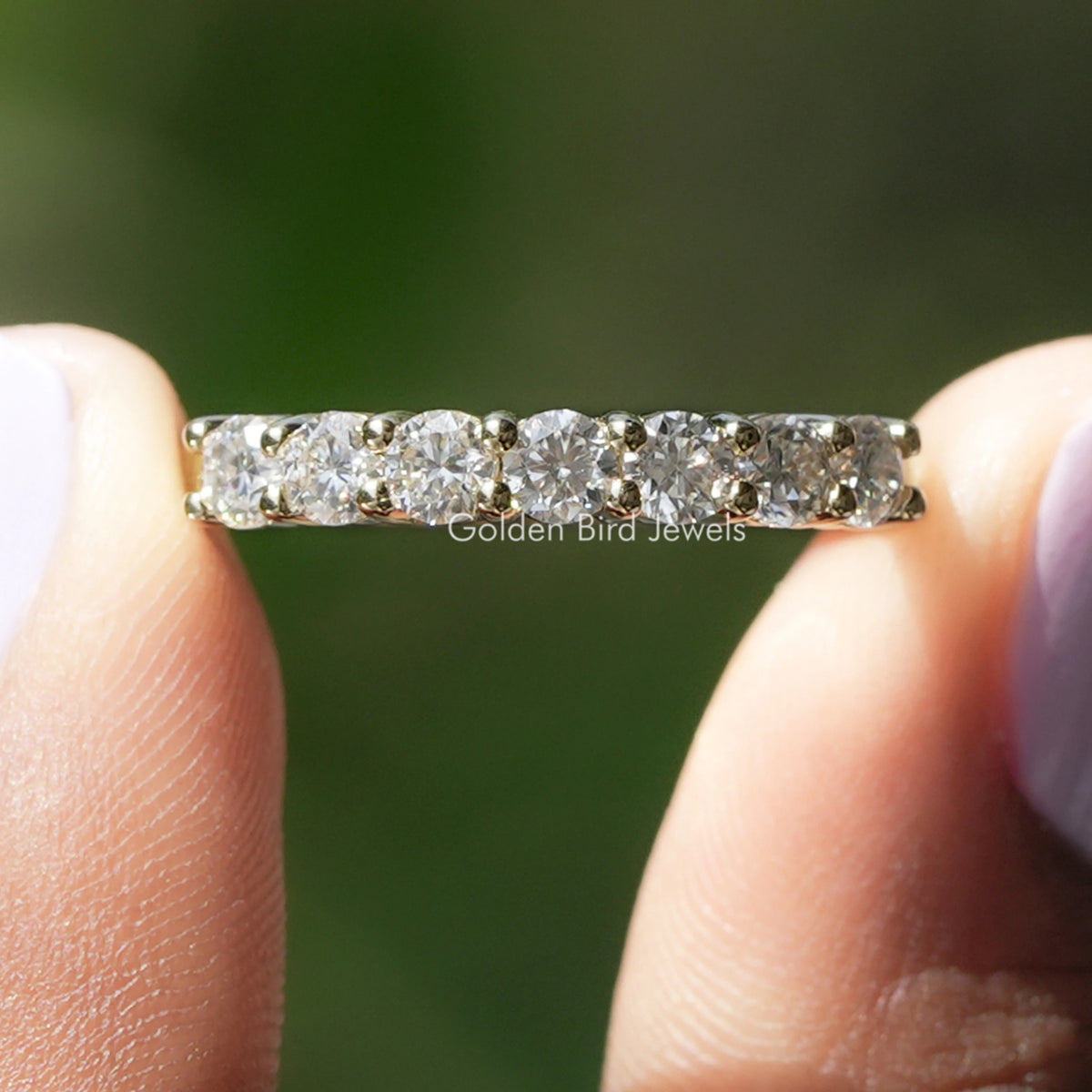 Half eternity ring with round colorless moissanite stones in a silver band