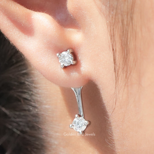 Close-up of silver-tone round moissanite stud and drop earring with screw-back post