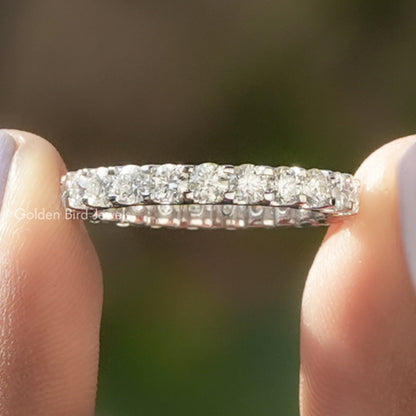 Close-up of round-stone full eternity wedding band row, silver-toned metal setting