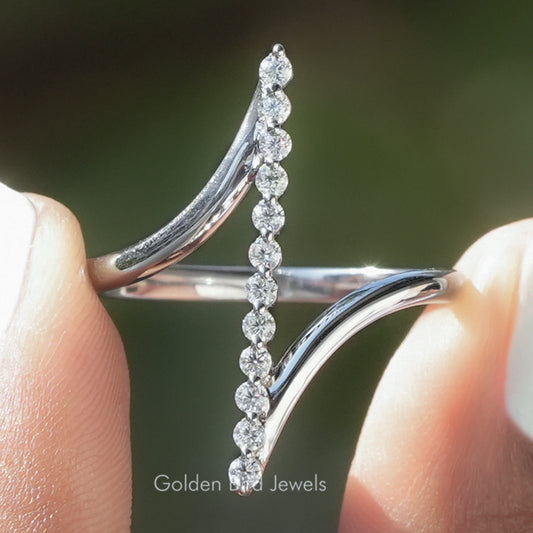 Silver bypass ring with vertical row of round moissanite stones and curved bands