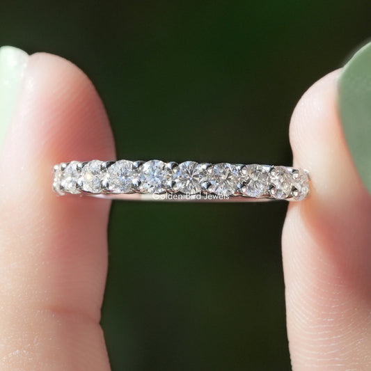 Close-up of silver half-eternity ring with round-cut stones in a straight row