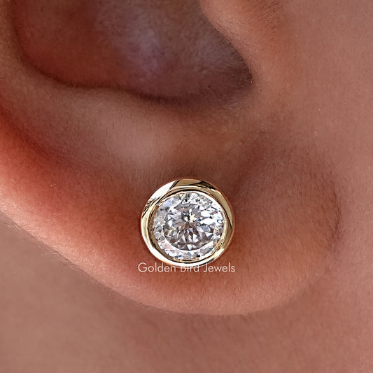 Gold-tone round moissanite stud earrings with raised bezel setting