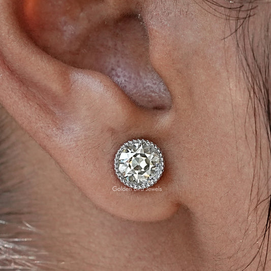 Round moissanite stud earrings with clear bezel-set center stone