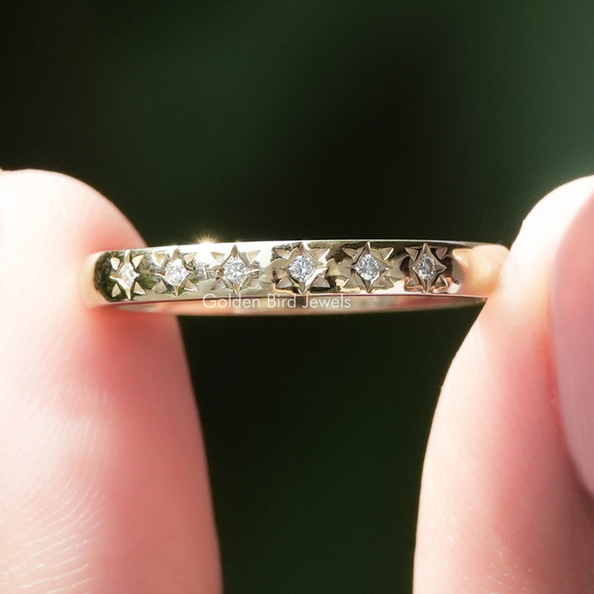 Silver flush wedding band with small round moissanite stones in a continuous row