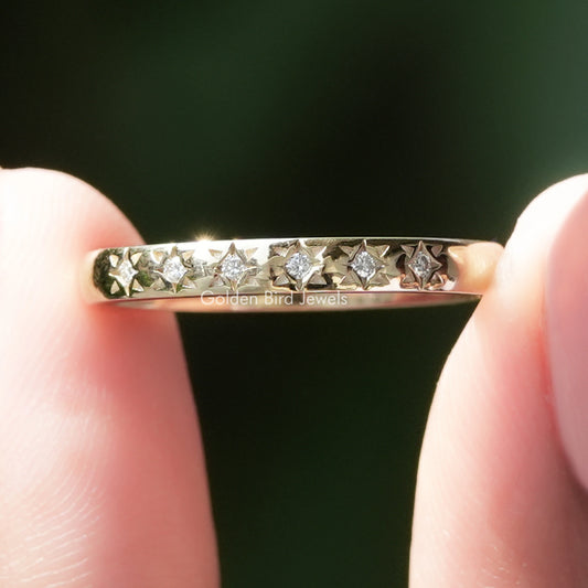 Silver flush wedding band with small round moissanite stones in a continuous row