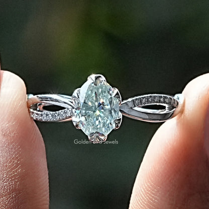Oval-cut moissanite engagement ring with twisted band and sparkling side stones