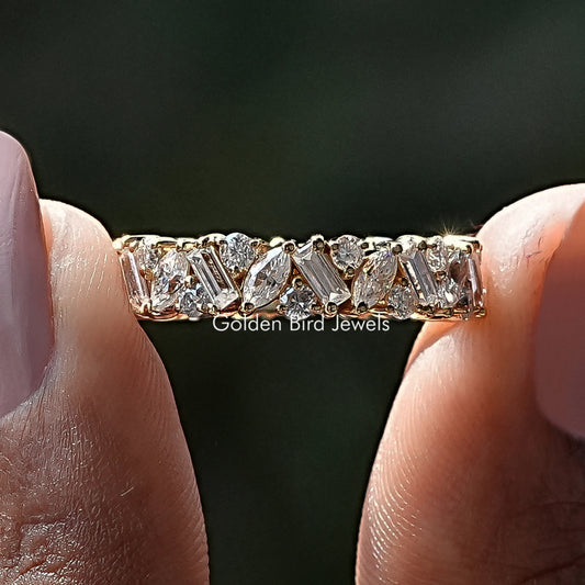 Gold moissanite eternity band with marquise and baguette stones, close-up