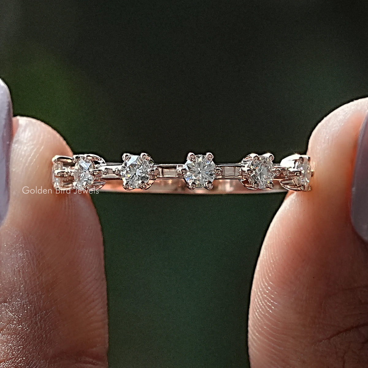 Half eternity ring with round moissanite stones across the top, metal band