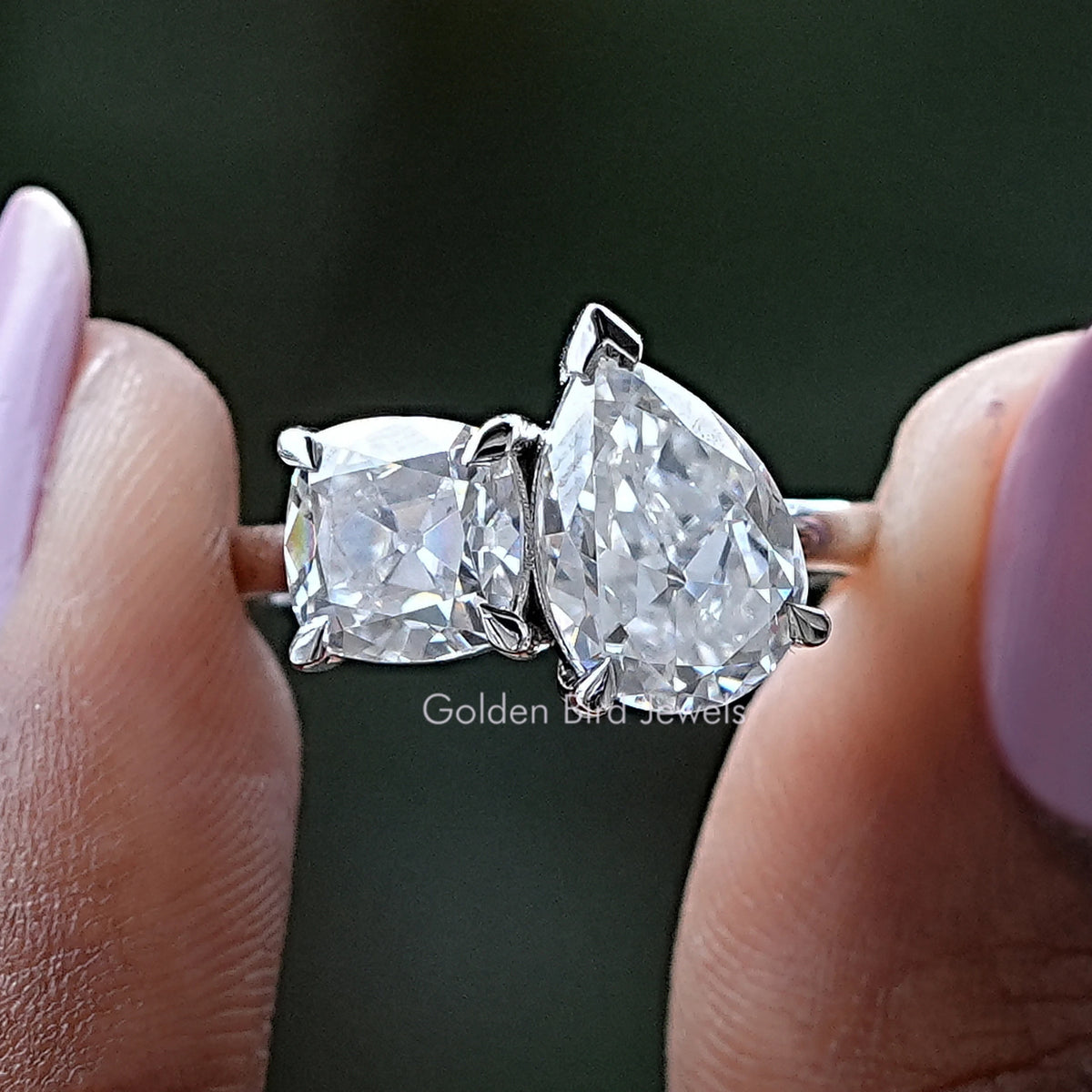 Silver-tone moissanite ring with pear and cushion-cut stones, prong-set