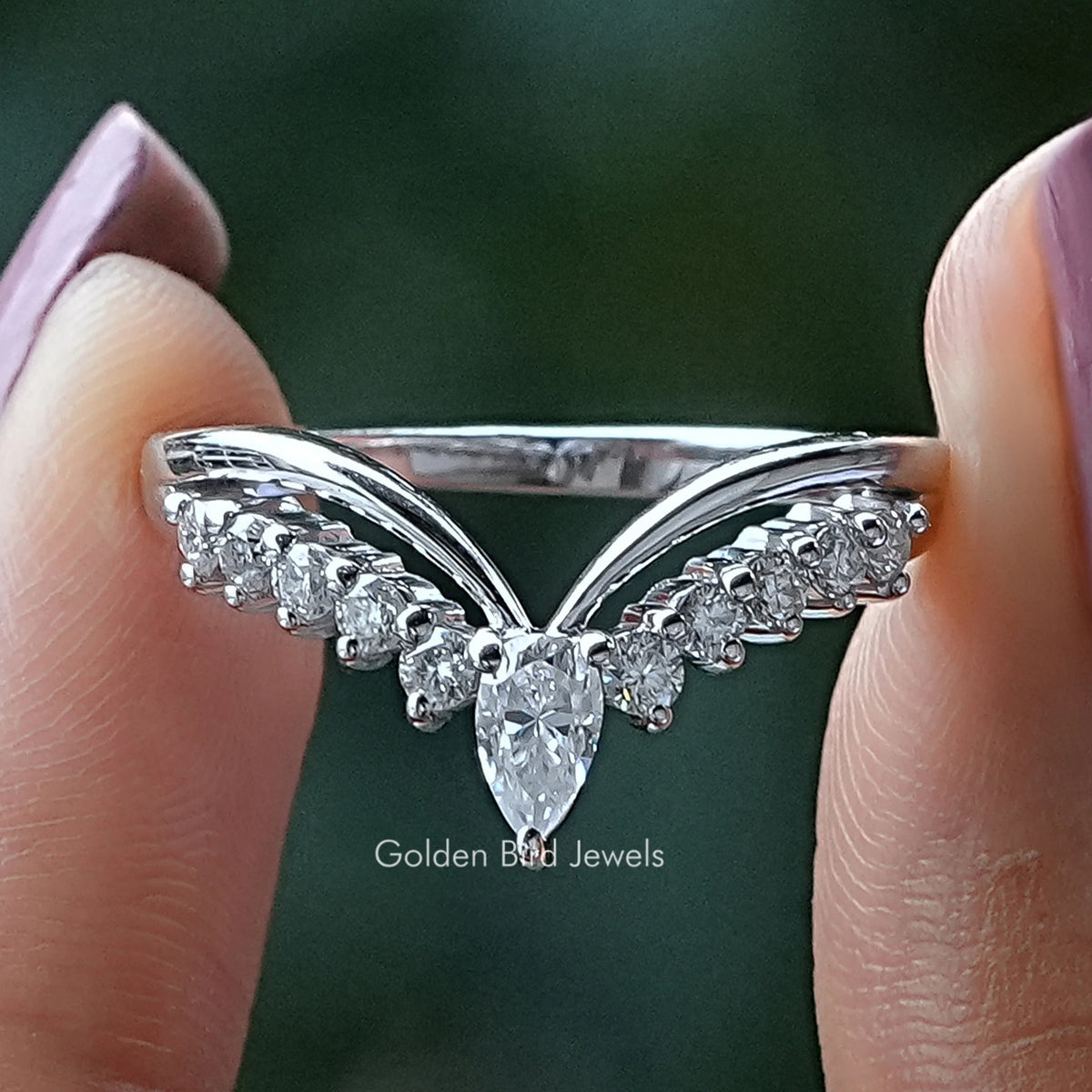 Close-up of silver chevron wedding band with pear-shaped clear stones