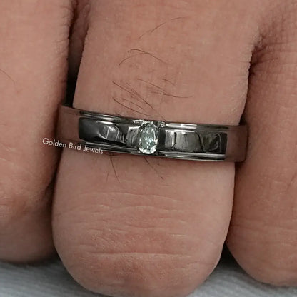 Men's wedding band with bright oval-cut stones on a dark metal band