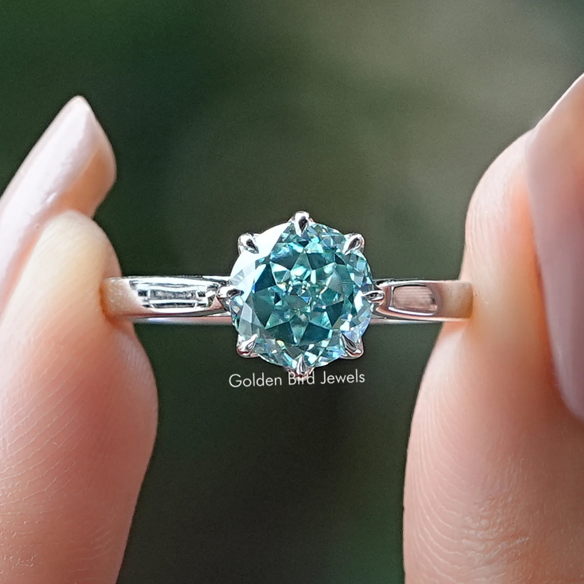Cyan blue round-cut moissanite ring with prong-set center stone on silver band