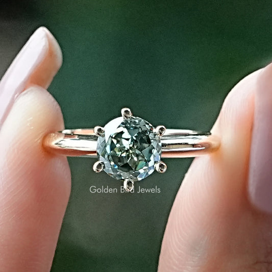 Round moissanite solitaire ring with four-prong setting and thin polished band