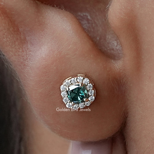 Halo moissanite stud earring with cushion-cut blue-green center stone in ear