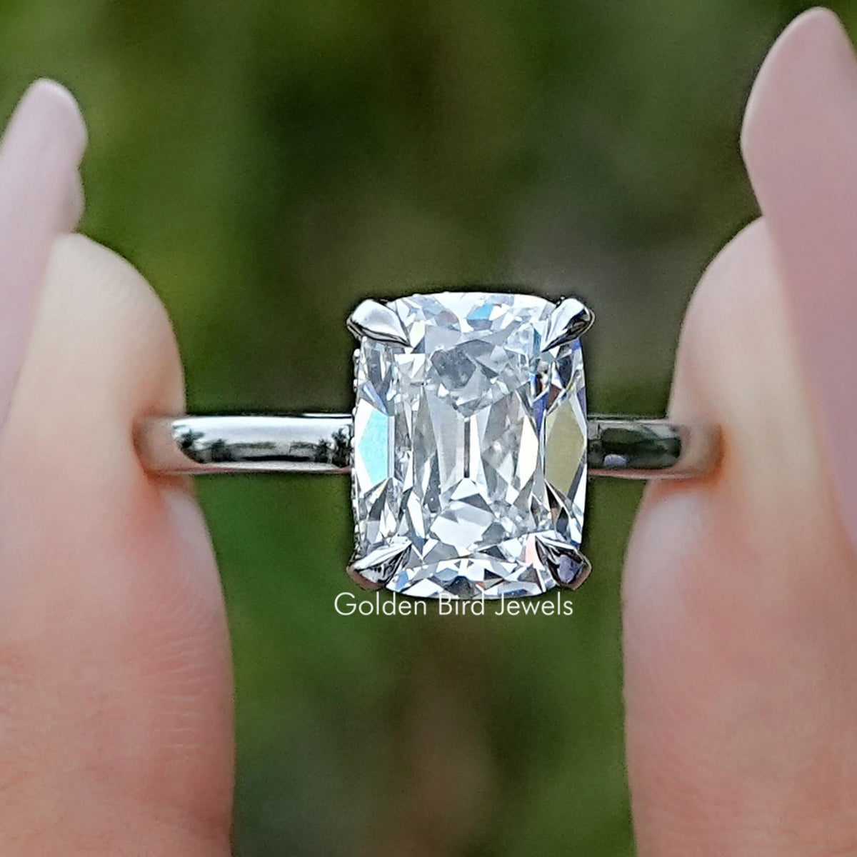 Old Mine Elongated Cushion Hidden Halo Diamond Ring Held Between Fingers