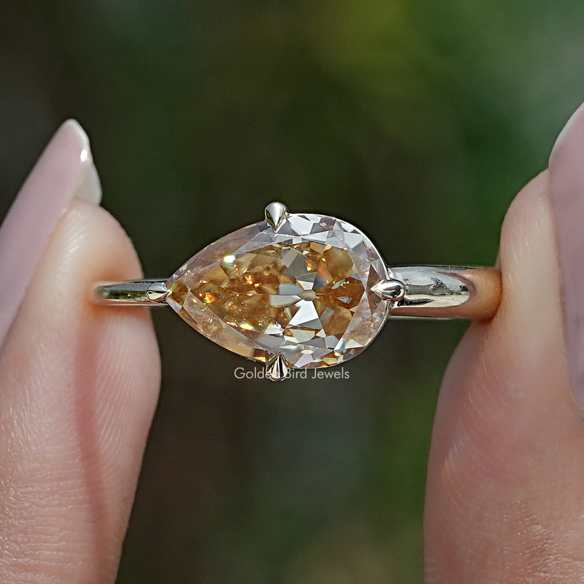 Pear-shaped moissanite east-west ring with split prong setting and metal band