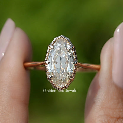 Oval moissanite ring with filigree bezel halo and rose-gold band