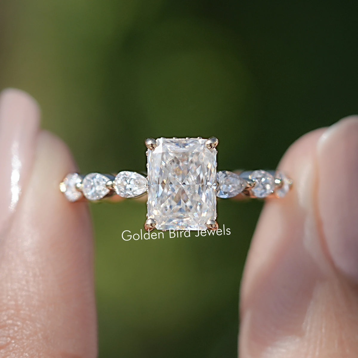Close-up silver-tone radiant-cut center with hidden halo and round side stones.