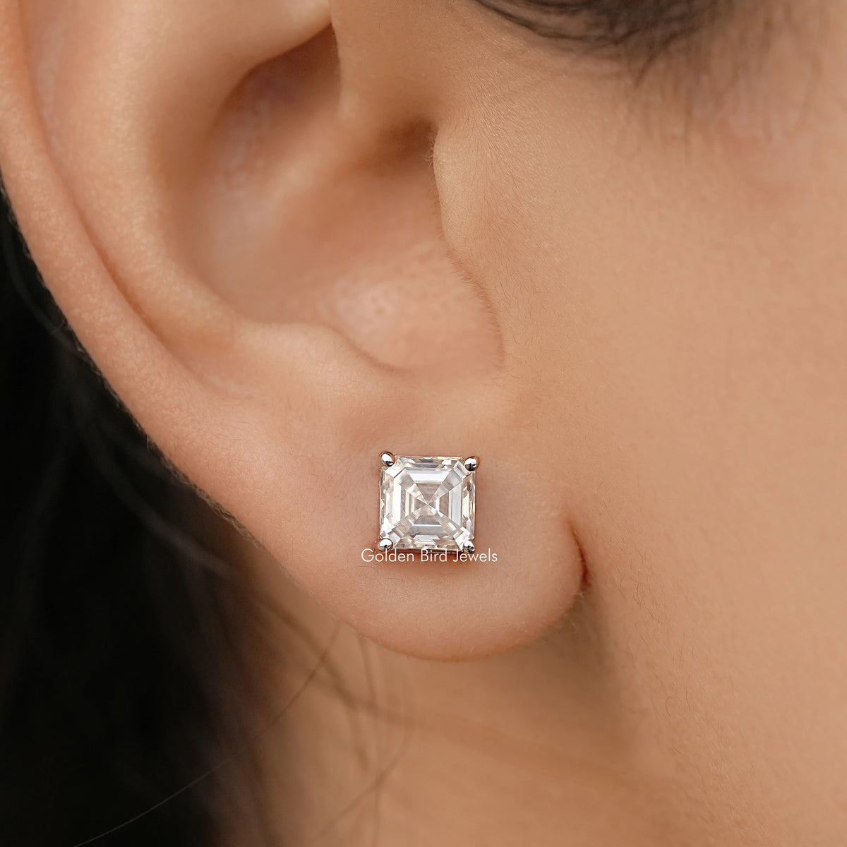 Asscher-cut moissanite stud earring with square stone bezel in white gold.