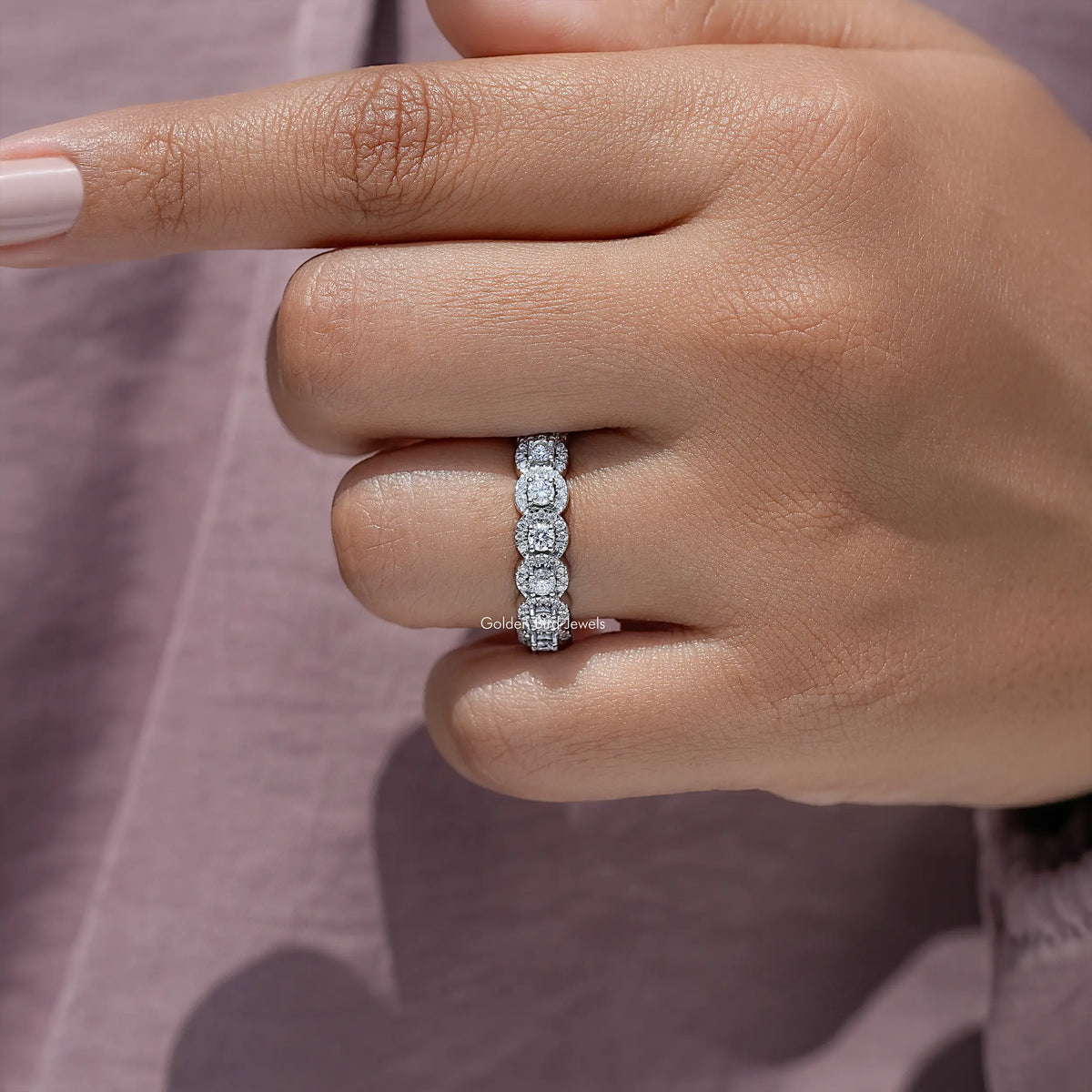 Round moissanite halo eternity band on a hand