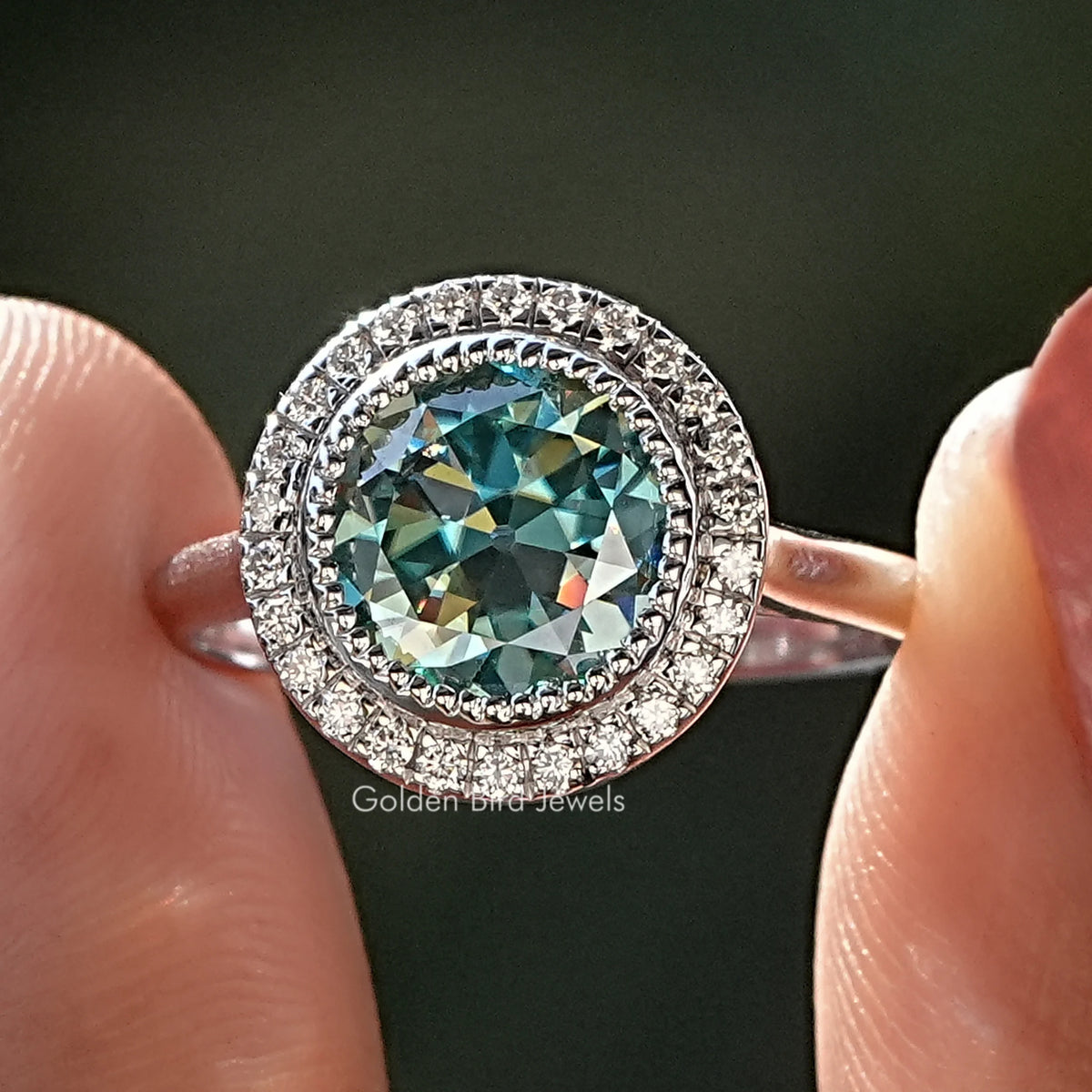 Moissanite halo bridal ring with round blue-green center stone and pavé band