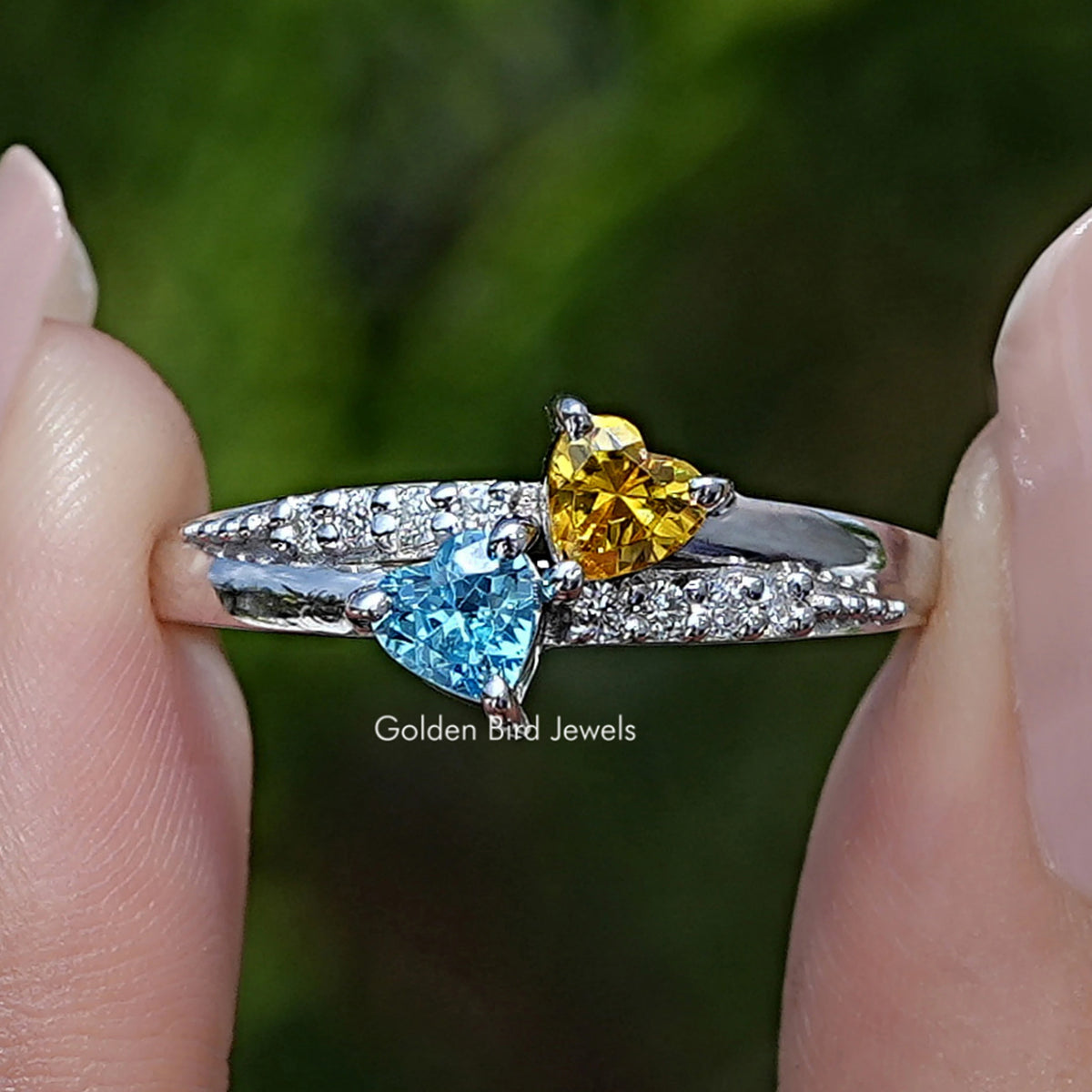 Heart-shaped gemstone accent ring with blue and yellow stones on silver band