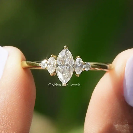 Gold moissanite engagement ring with marquise center and small side stones
