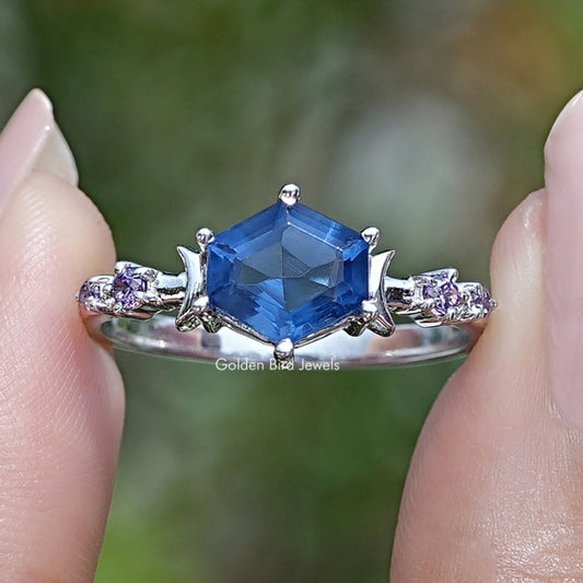 Sapphire blue hexagon gemstone engagement ring with side stones and prong setting