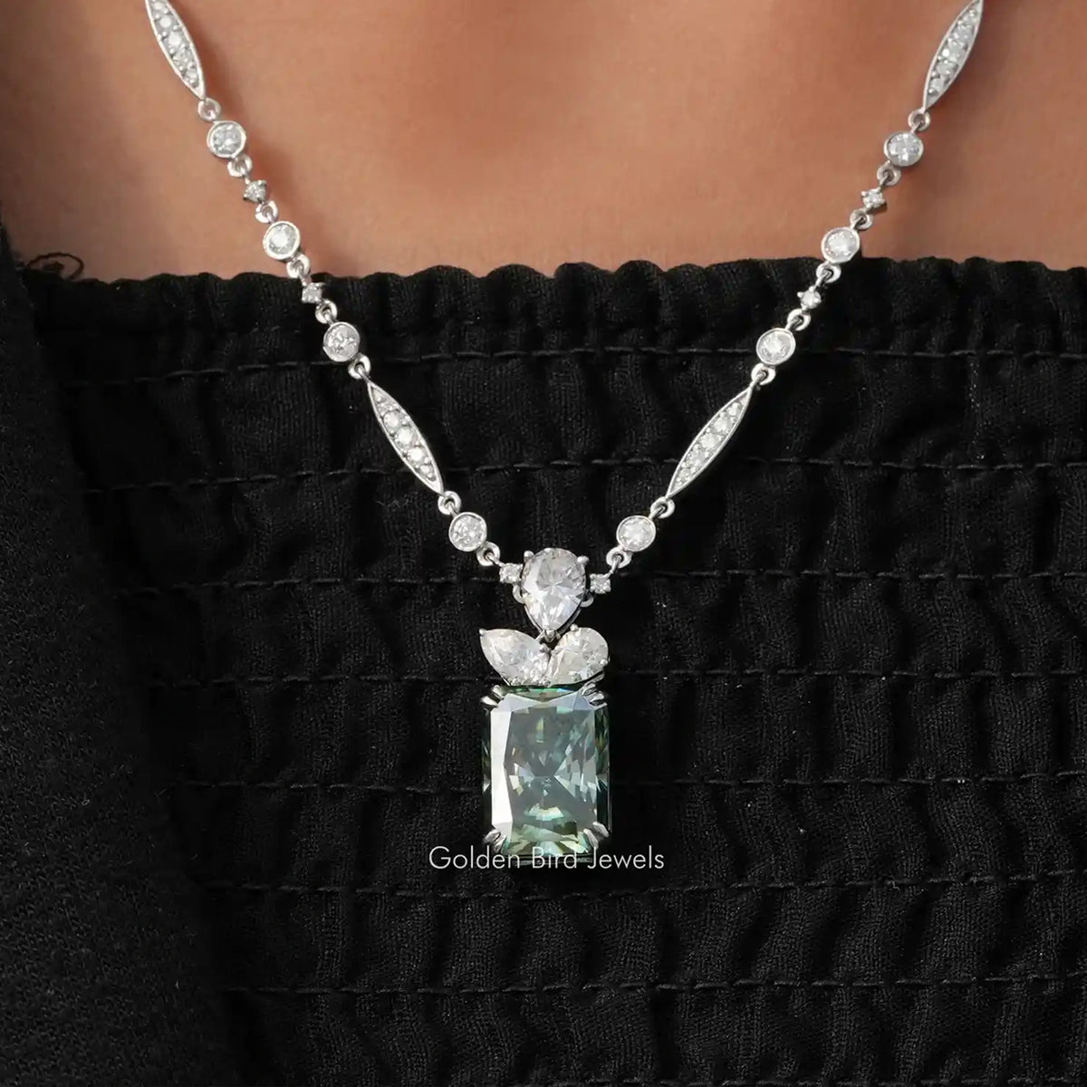 Sterling silver moissanite wedding necklace with oval and round stones, pear-shaped center