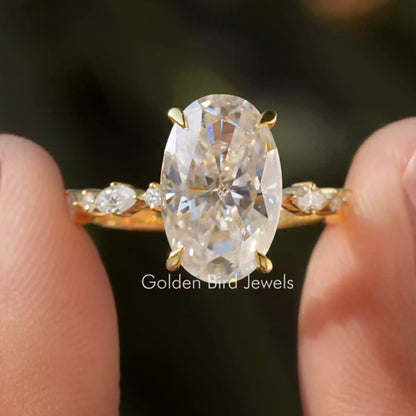 Oval moissanite eternity ring with gold band, large center stone and small side stones