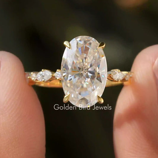 Oval moissanite eternity ring with gold band, large center stone and small side stones