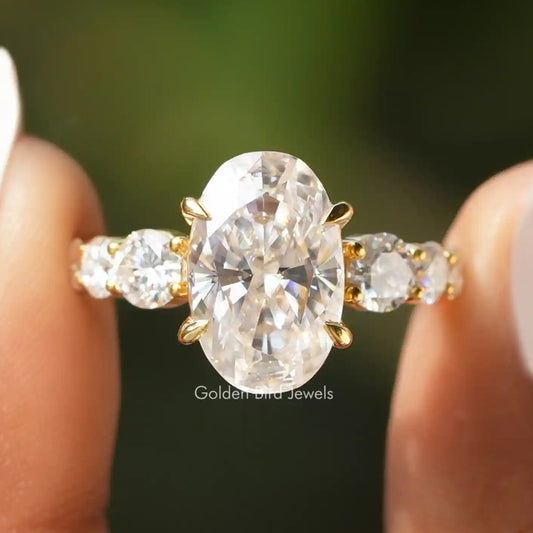 Oval moissanite engagement ring, gold-tone prong setting, side stones