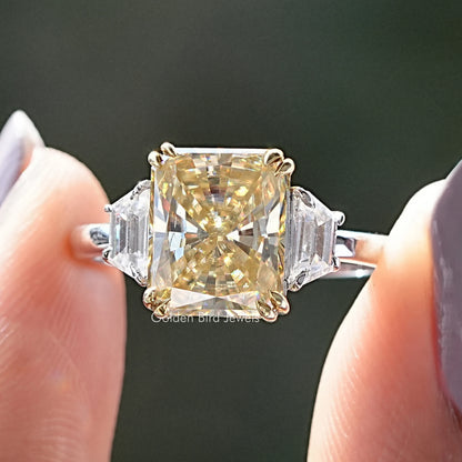 Three-stone yellow radiant moissanite ring with square center and baguette side stones