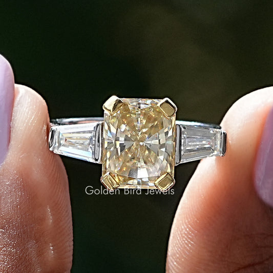 Three-stone moissanite ring with center yellow cushion stone and baguette side stones