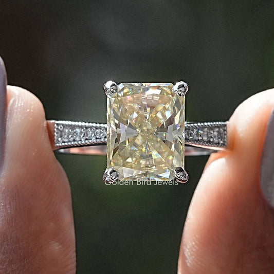 Radiant cut moissanite ring with pave accent stones on a slim band