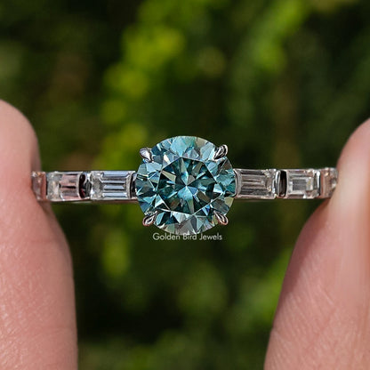 Close-up of silver moissanite accent ring, large round blue center and baguette details