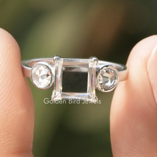 Three-stone moissanite ring with square center and round side stones, silver band