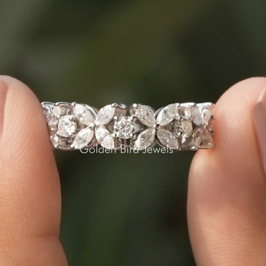 Silver wedding band with round cut moissanite stones across the band