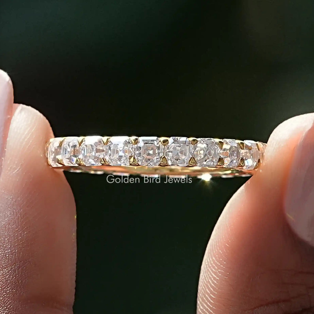 Silver-tone eternity band close-up showing square-cut moissanite stones
