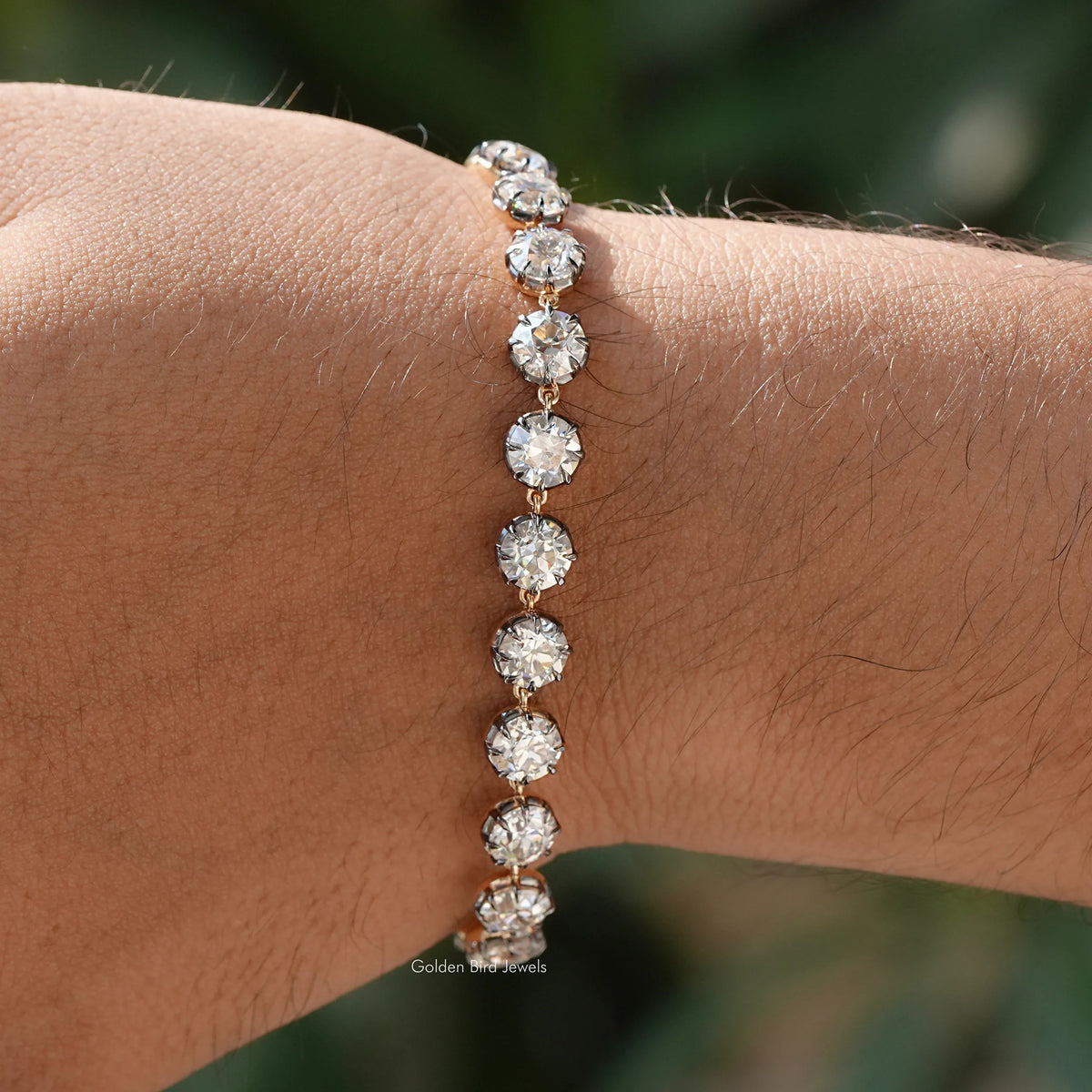 Round-cut moissanite tennis bracelet with round stones in silver setting on wrist