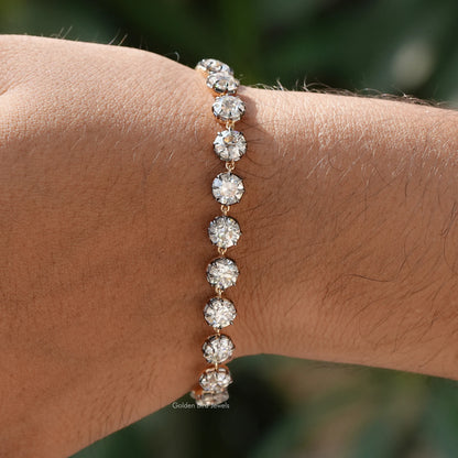 Round-cut moissanite tennis bracelet with round stones in silver setting on wrist